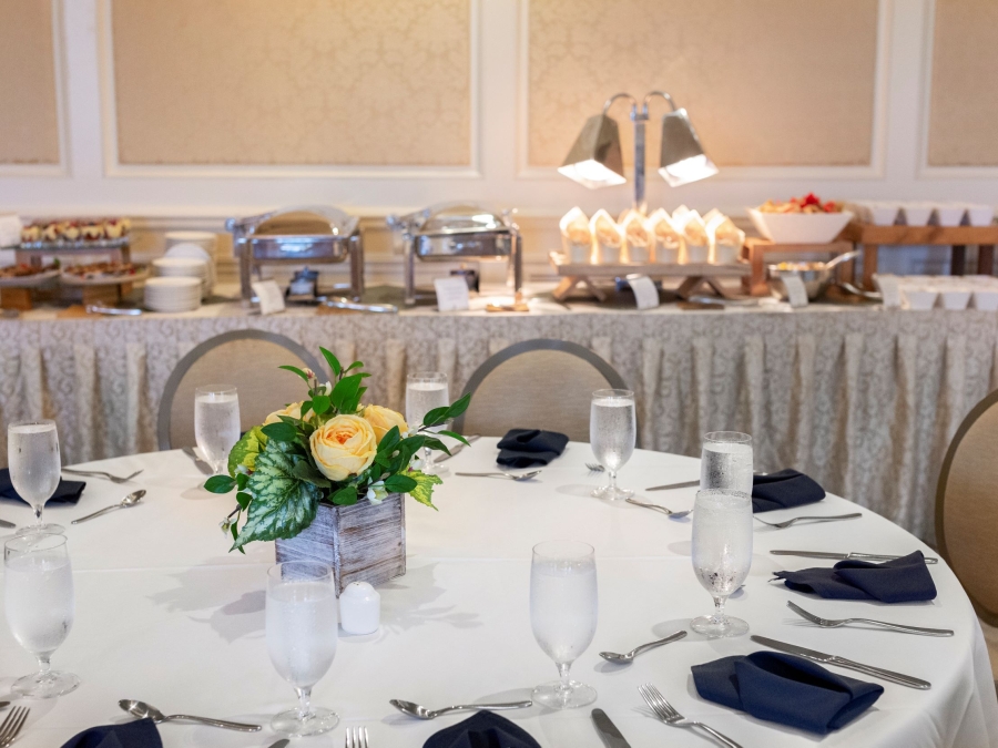 A table setup in the Harbour Town Clubhouse with glasses and silverware and a buffet in the background. 