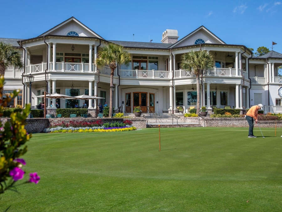 Man golfing in-front of Links restaurant 