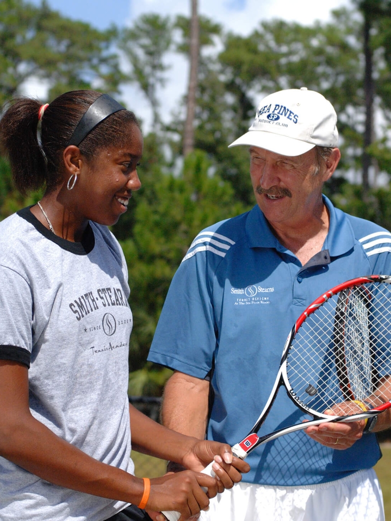 man talking to tennis player