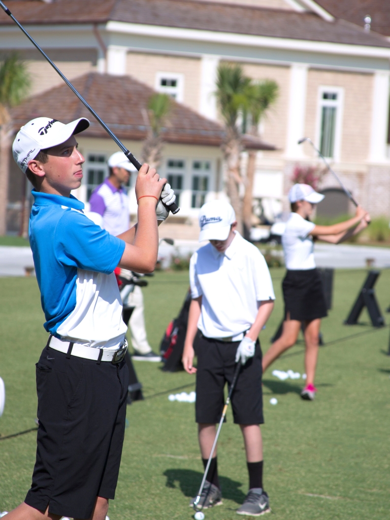 Children practicing golf at the driving range  