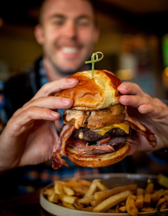 Man holding a very large burger 