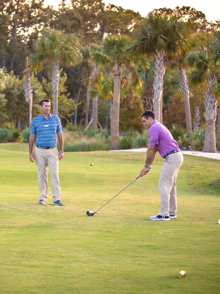 Golf instructor coaching a man 