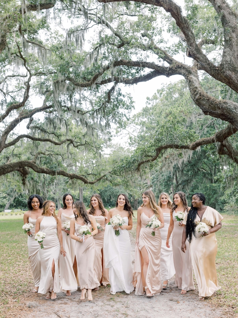 Girls bridal party posing under trees 