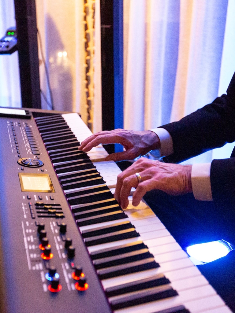 A man playing the piano with a jazz band. 