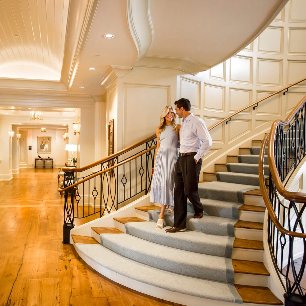 A couple walking down a grand staircase 
