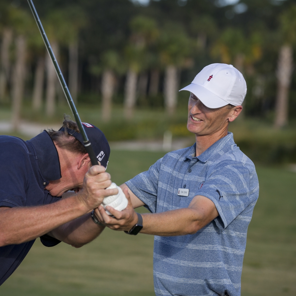Golf coach teaching a man 